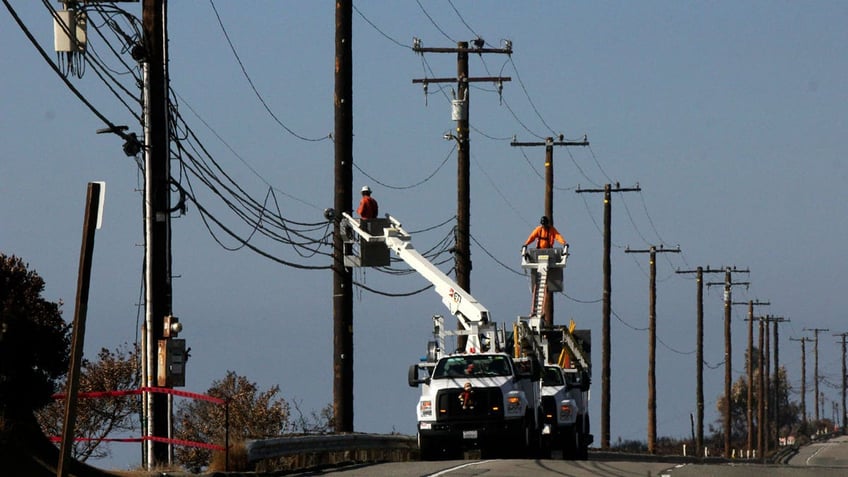 Utility crews repair overhead lines along Pacific Coast Highway just west of Malibu