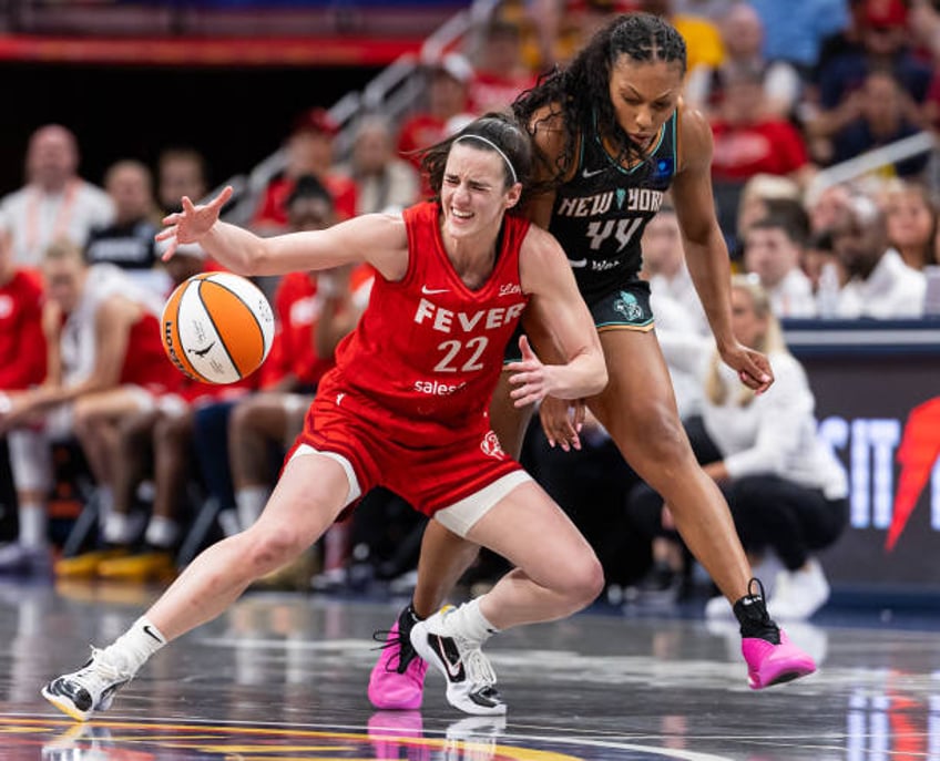 Caitlin Clark of the Indiana Fever loses the ball as Betnijah Laney-Hamilton of the New York Liberty defends during the first half at Gainbridge...