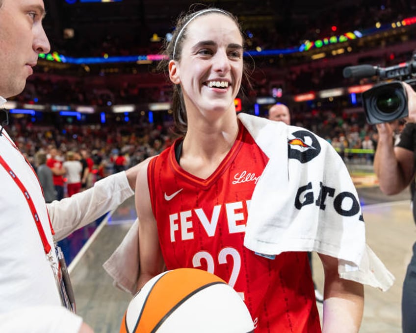 Caitlin Clark of the Indiana Fever is presented the game ball after becoming the first rookie to score a triple double against the New York Liberty...