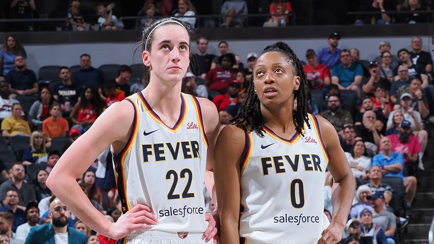 Caitlin Clark and Kelsey Mitchell stand on the basketball court