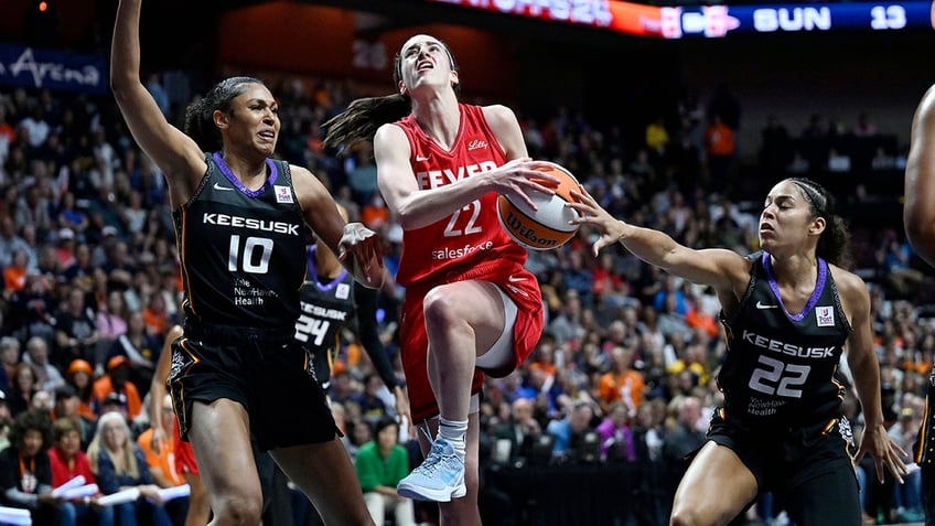 Indiana Fever guard Caitlin Clark, #22, is goes to the basket as Connecticut Sun forward Olivia Nelson-Ododa, #10, and guard Veronica Burton, #22, defend during the first half of Game 2 of a first-round WNBA basketball playoff series on Wednesday, Sept. 25, 2024, in Uncasville, Connecticut.