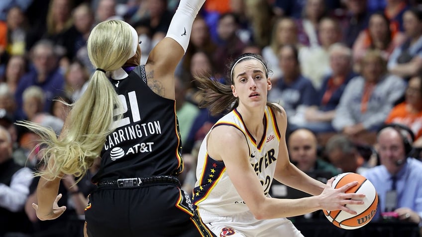 Caitlin Clark faces a defender