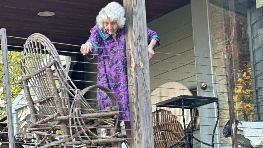 Ms. Jo Jane stands next to a rocking chair