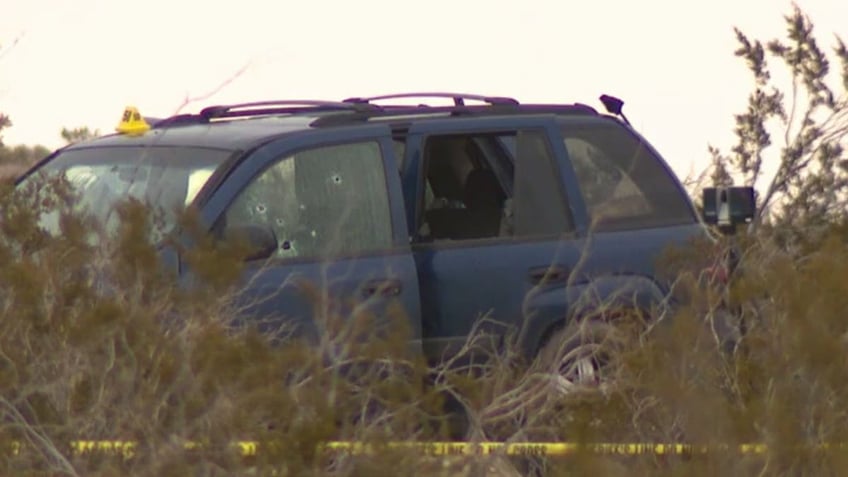 SUV with bullet holes in desert