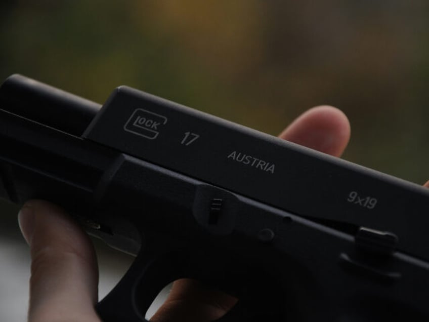 person-holding-black-semi-automatic-pistol