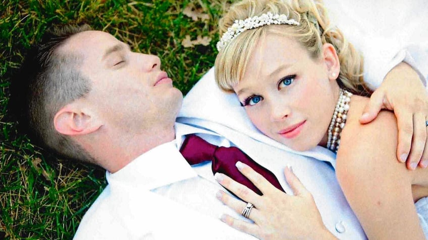 Keith Papini laying on grass as Sherri Papini caresses him in her wedding dress.