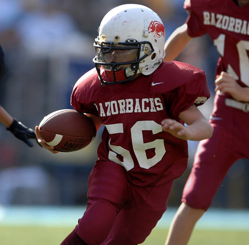 Youth Pee-Wee football player heads up field during pre-game exhibition before game between the Arizona Cardinals and San Diego Chargers at Qualcomm...