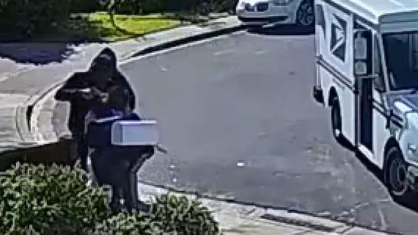 The postal worker being robbed at gunpoint