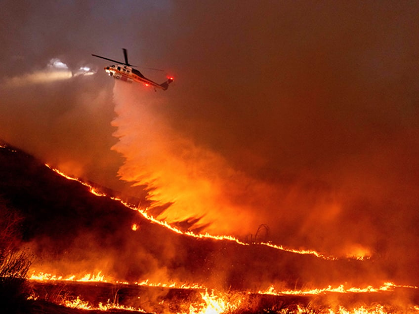 Water is dropped by helicopter on the Kenneth Fire in the West Hills section of Los Angele