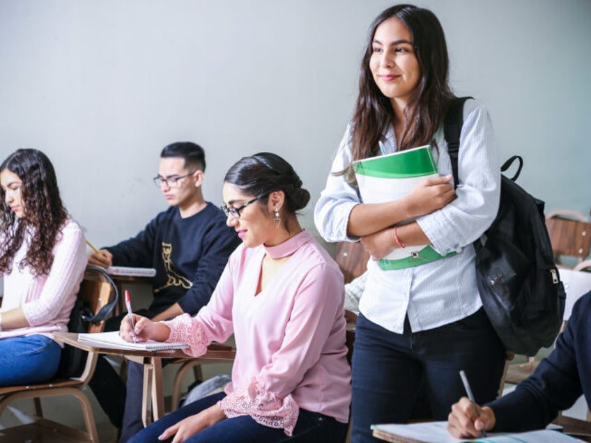 Classroom with one student standing (Unsplash/Javier Trueba)