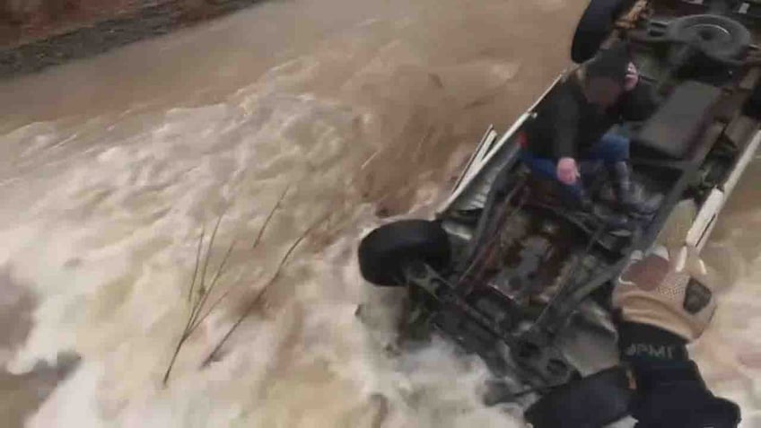 woman on top of overturned car