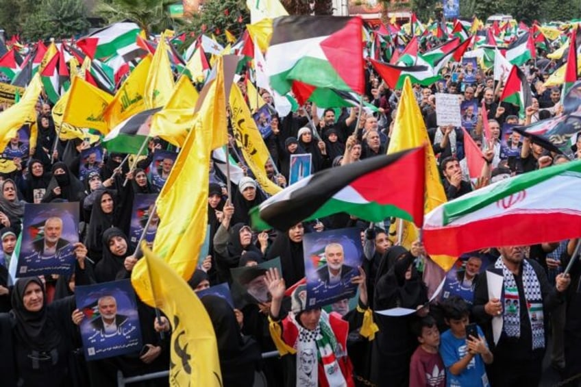 Iranians wave Palestinian flags and hold portraits of slain Hamas leader Ismail Haniyeh at