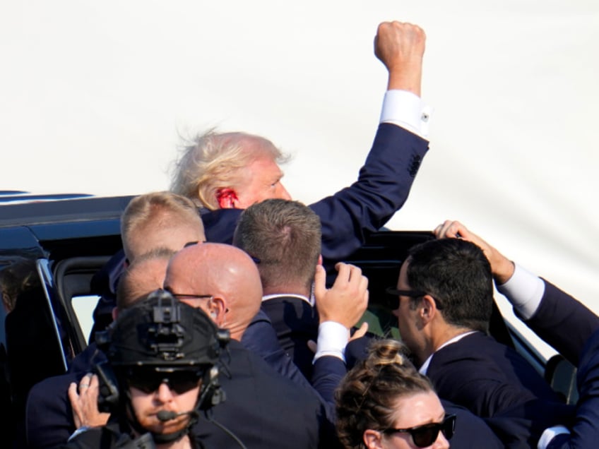 Republican presidential candidate former President Donald Trump pumps his fist as he is escorted into a vehicle at a campaign event in Butler, Pa., on Saturday, July 13, 2024. (AP Photo/Gene J. Puskar)