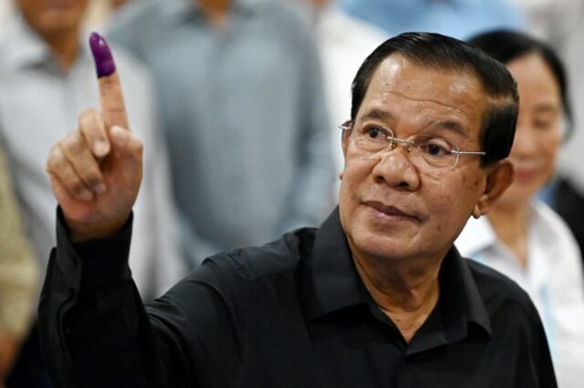 Cambodia's former prime minister Hun Sen shows his inked finger after voting during the Se