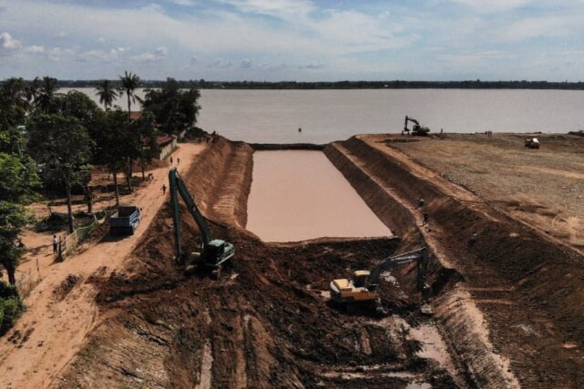 Workers use excavators to dig the Funan Techo canal, a $1.7 billion project that will run