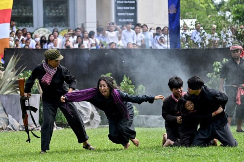 Cambodian students re-enact Khmer Rouge crimes at an annual remembrance of a genocide that