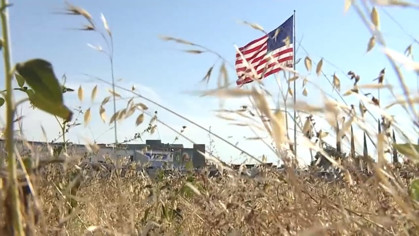 A giant U.S. flag flies atop a 130-foot-tall flag pole outside RV retailer Camping World's French Camp, California.