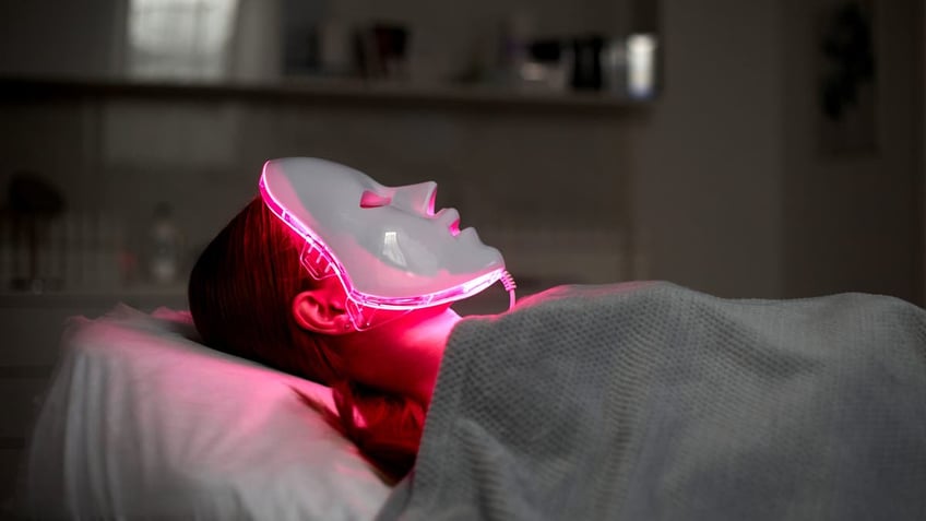 Person in red light therapy mask.