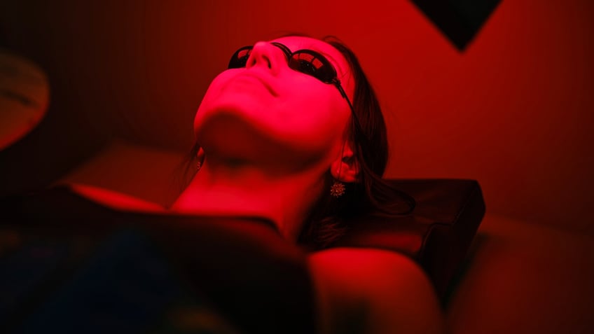 Person receiving red light therapy while laying horizontal