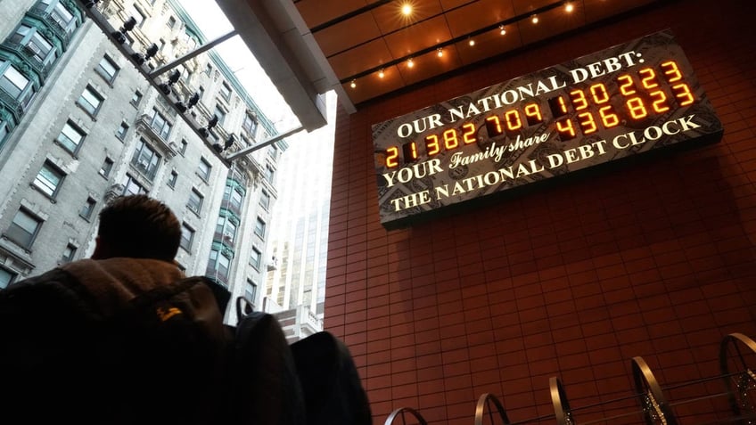 A man walks past the National Debt Clock on 43rd Street in midtown New York City, Feb. 15, 2019. The debt has now passed $35 trillion. (Getty Images)