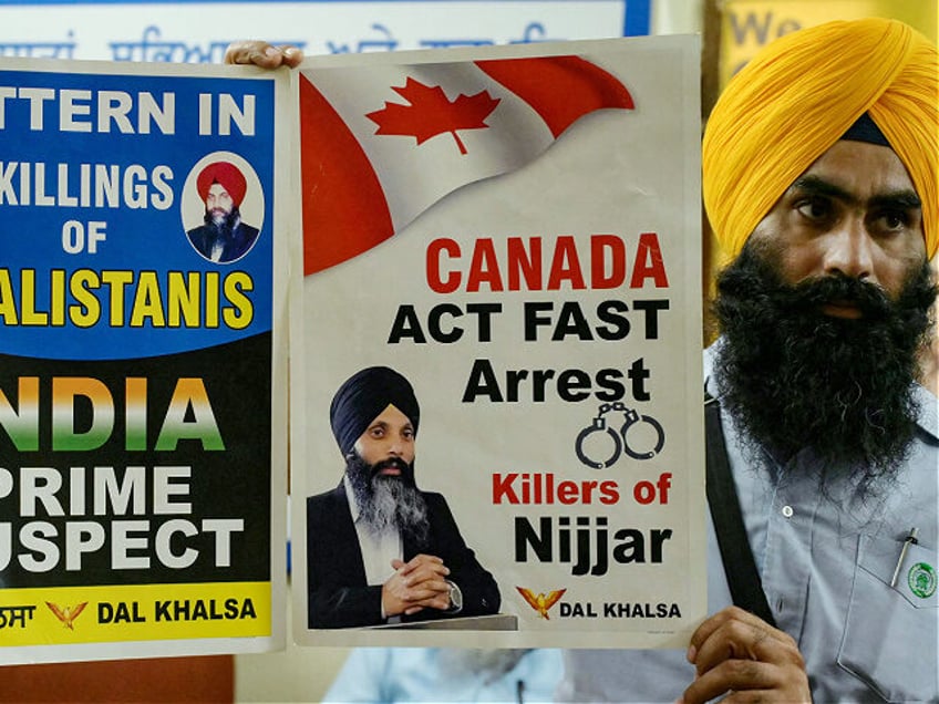 A member of a Sikh organisation holds a placard displaying Sikh separatist Hardeep Singh N