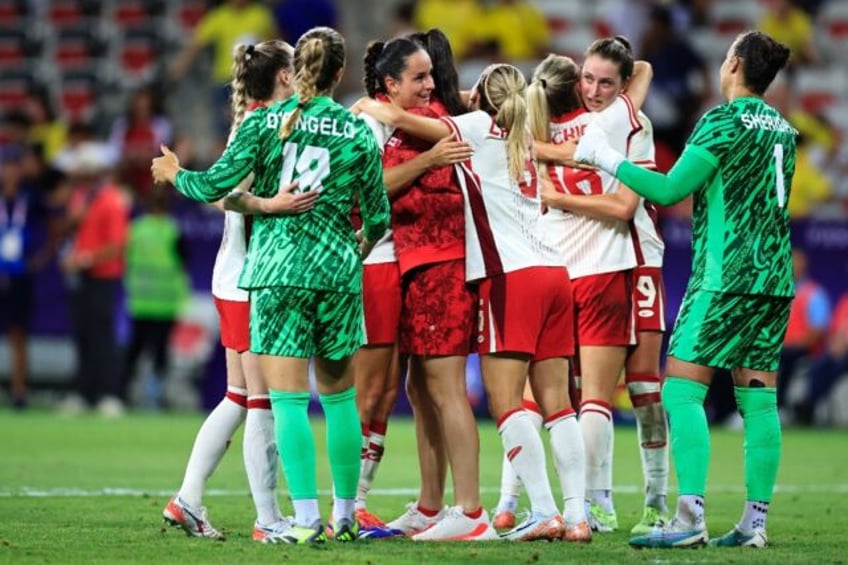 Canada's players celebrate after beating Colombia to qualify for the quarter-finals at the