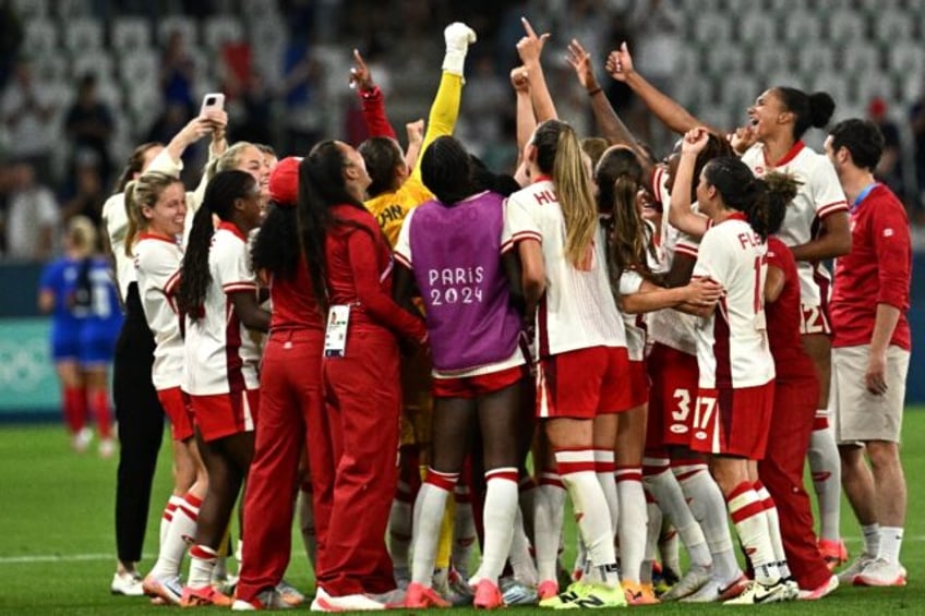 Canada players celebrate after beating France on Sunday to keep their Olympic campaign ali