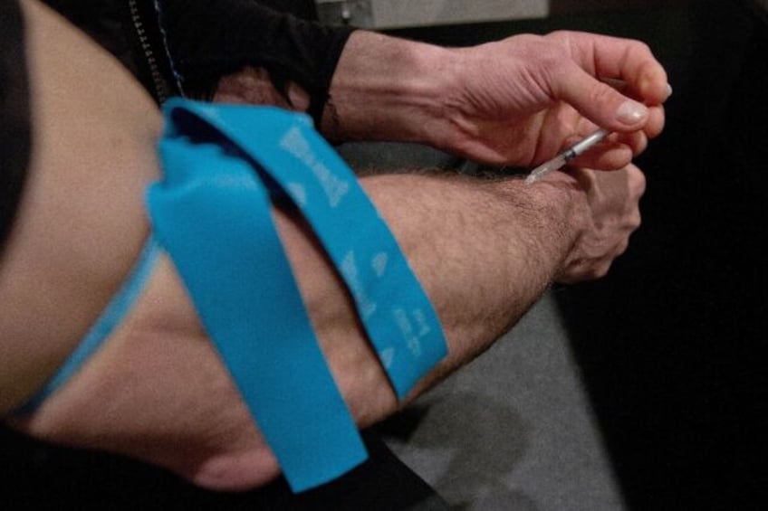 A man injects heroin at a supervised injection site in Vancouver