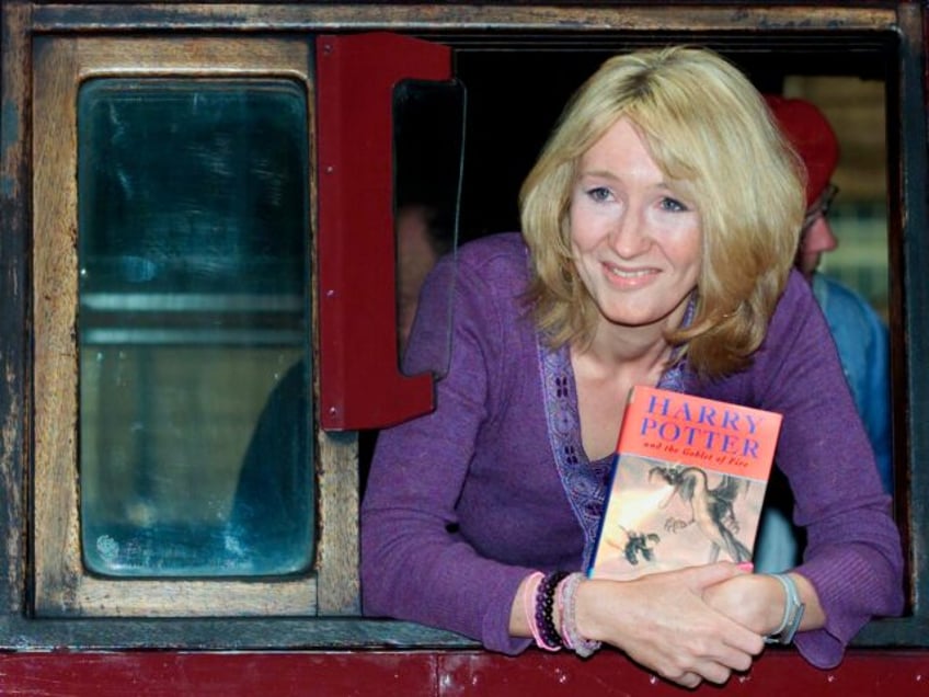 Author J. K. Rowling leans out of a steam train named "Hogwarts Express" at Kings Cross ra