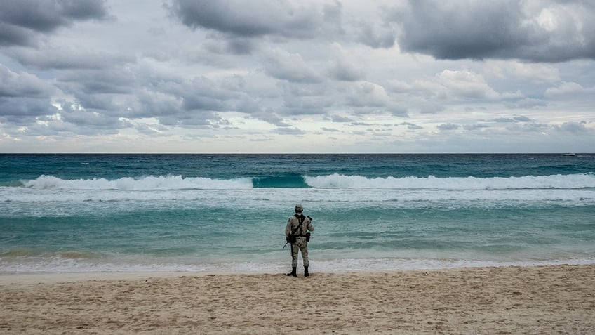 member of the National Guard patrols a beach