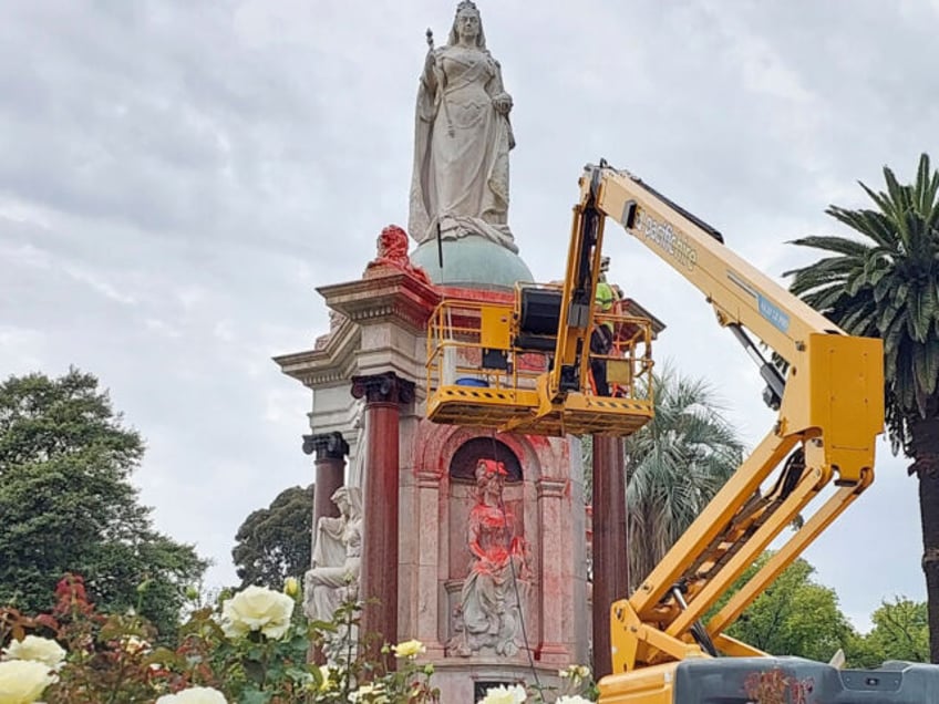 A council worker cleans the statue to Britain's Queen Victoria that was defaced in the Royal Botanic Gardens Victoria in Melbourne on January 25, 2024, ahead of Australia Day. (Photo by Martin PARRY / AFP) (Photo by MARTIN PARRY/AFP via Getty Images)