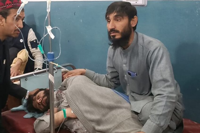 A man takes care of his injured relative in a hospital after the bomb blasts in Bannu