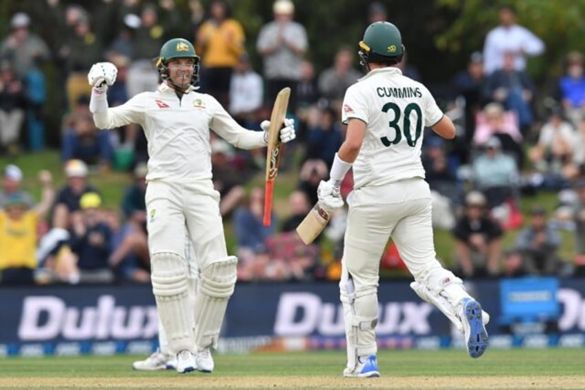 Alex Carey (L) and Pat Cummins celebrate Australia's second Test victory over New Zealand