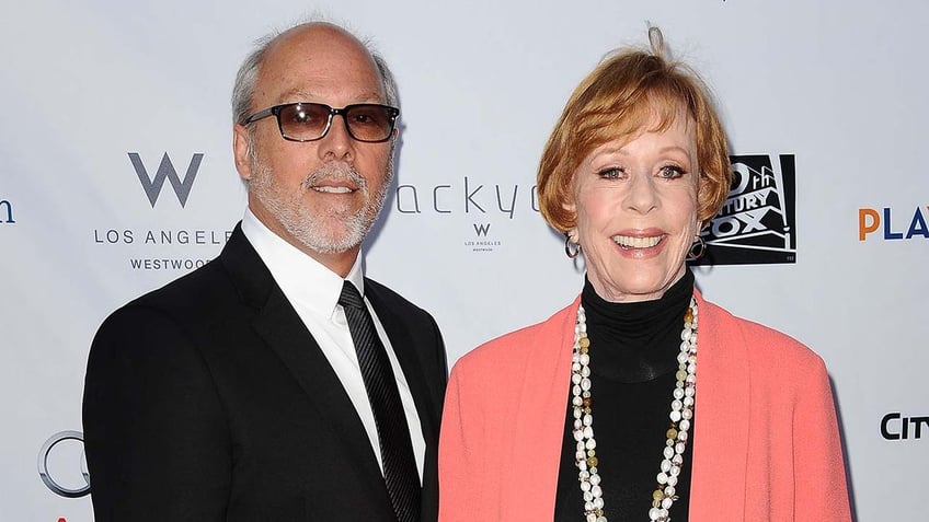 Actress Carol Burnett sports pink coat with black top and beaded necklace for Hollywood event with husband Brian Miller.