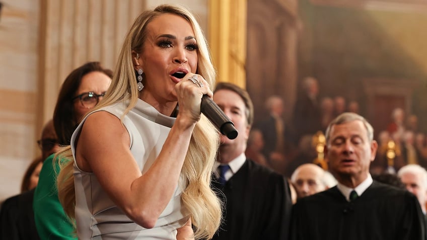 Carrie Underwood in a silver/grey dress performs "America The Beautiful" at the inauguration of President Trump