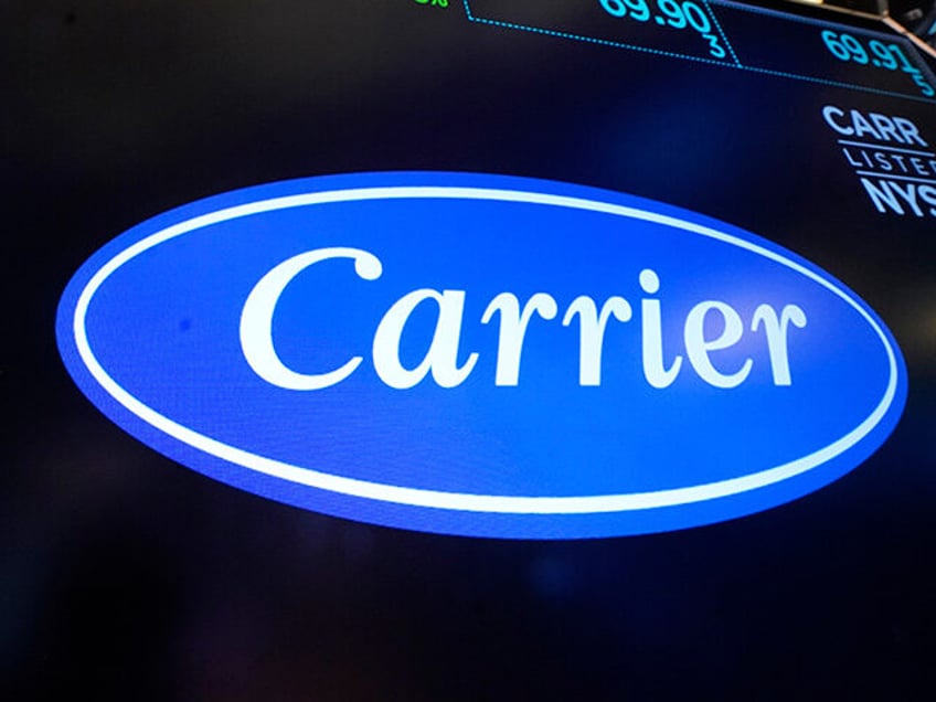 The logo for Carrier appears above a trading post on the floor of the New York Stock Excha