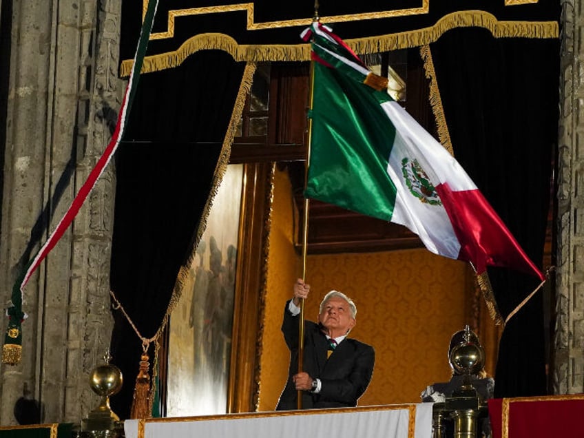 Mexican President Andres Manuel Lopez Obrador waves the national flag after the annual ind