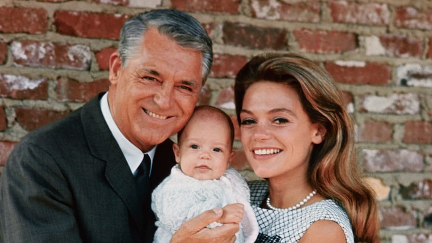 Cary Grant holding onto his baby Jennifer Grant with his wife Dyan Cannon