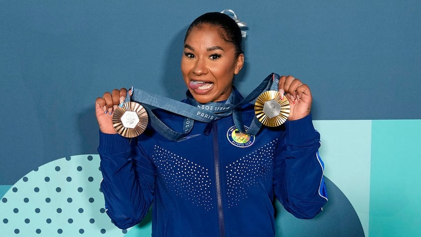 Jordan Chiles holds up her medals