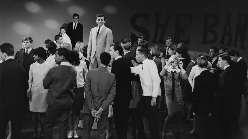 Casey Kasem surrounded by a crowd in a black and white vintage photo