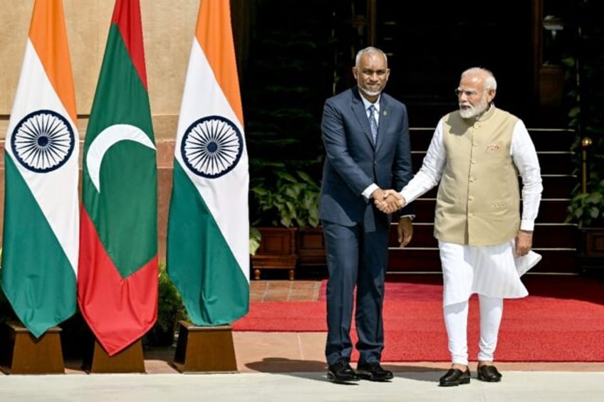 India's Prime Minister Narendra Modi (R) and Maldives President Mohamed Muizzu shake hands