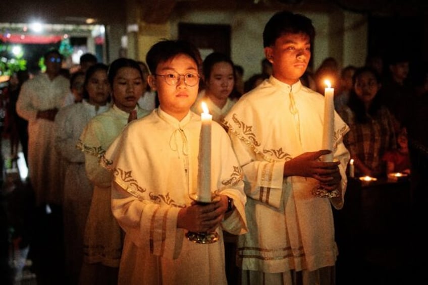 Catholic candle bearers take part in a Christmas Eve mass in Indonesia's Aceh