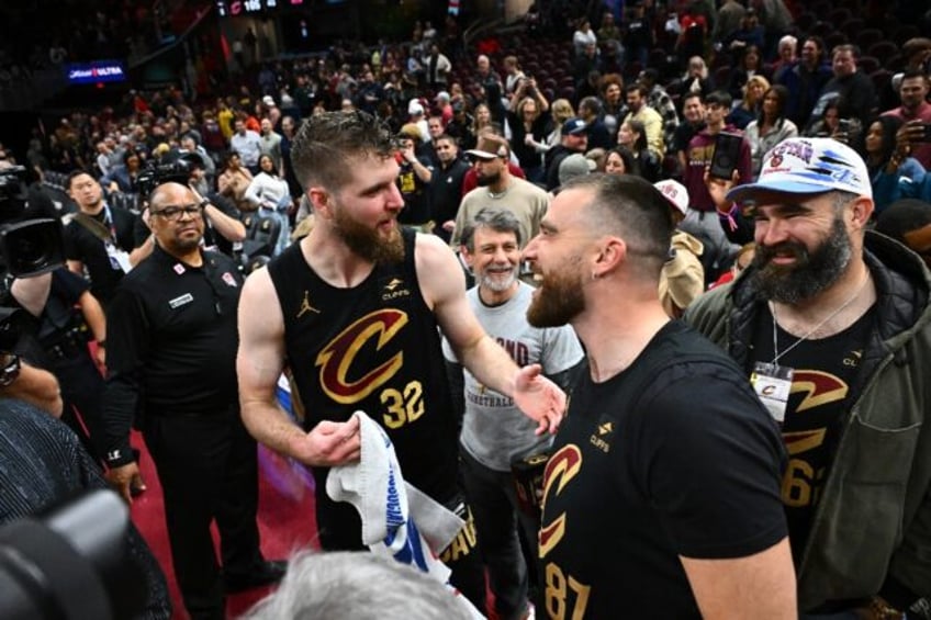 Cleveland Cavaliers player Dean Wade is congratulated by NFL stars Travis and Jason Kelce