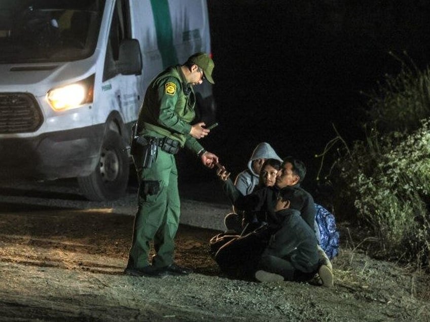 Asylum seekers wait to board border patrol vehicles near Campo Rd. after hiking 9 plus hou