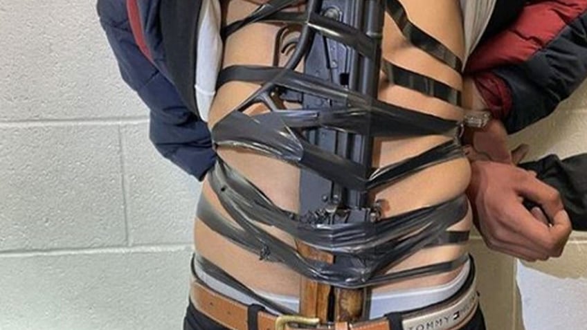 Illegal immigrant with a rifle taped to his chest