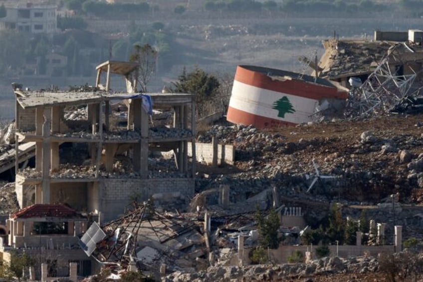 An Israeli flag hangs on a destroyed building while a Lebanese flag is painted on another