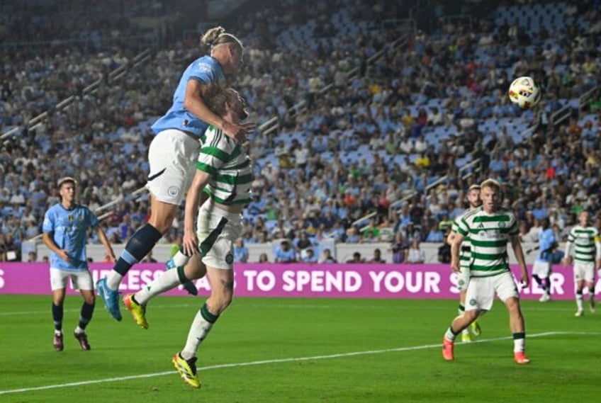 Manchester City's Norwegian striker Erling Haaland, top, heads the ball into the goal in t