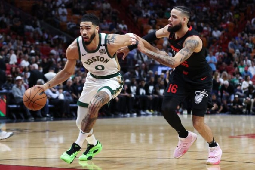 Boston's Jayson Tatum drives against Caleb Martin in the Celtics' NBA victory over the Mia