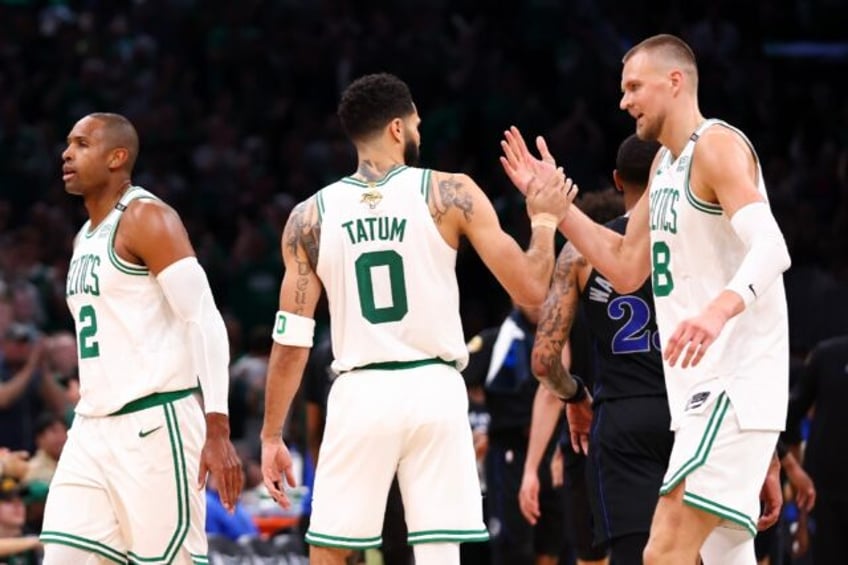 Kristaps Porzingis of the Boston Celtics celebrates with Jayson Tatum in the Celtics' vict