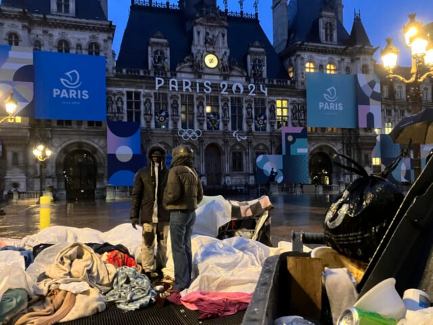 Migrants stand in front of the Paris City Hall, Wednesday, April 3, 2024. French police ha